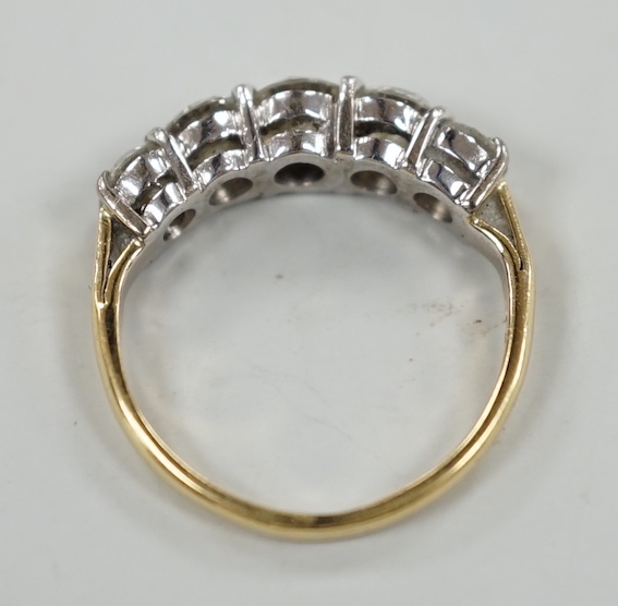 A gold and graduated five stone diamond set half hoop ring, size G/H, gross weight 2.7 grams.